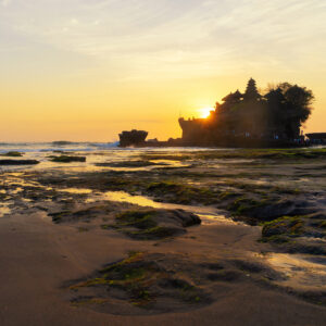 Pura Tanah Lot, the water temple, in Bali at sunset. It is one of the most popular of tourist attraction. Indonesia. Nature landscape background of travel trip and holidays vacation in Indonesia.